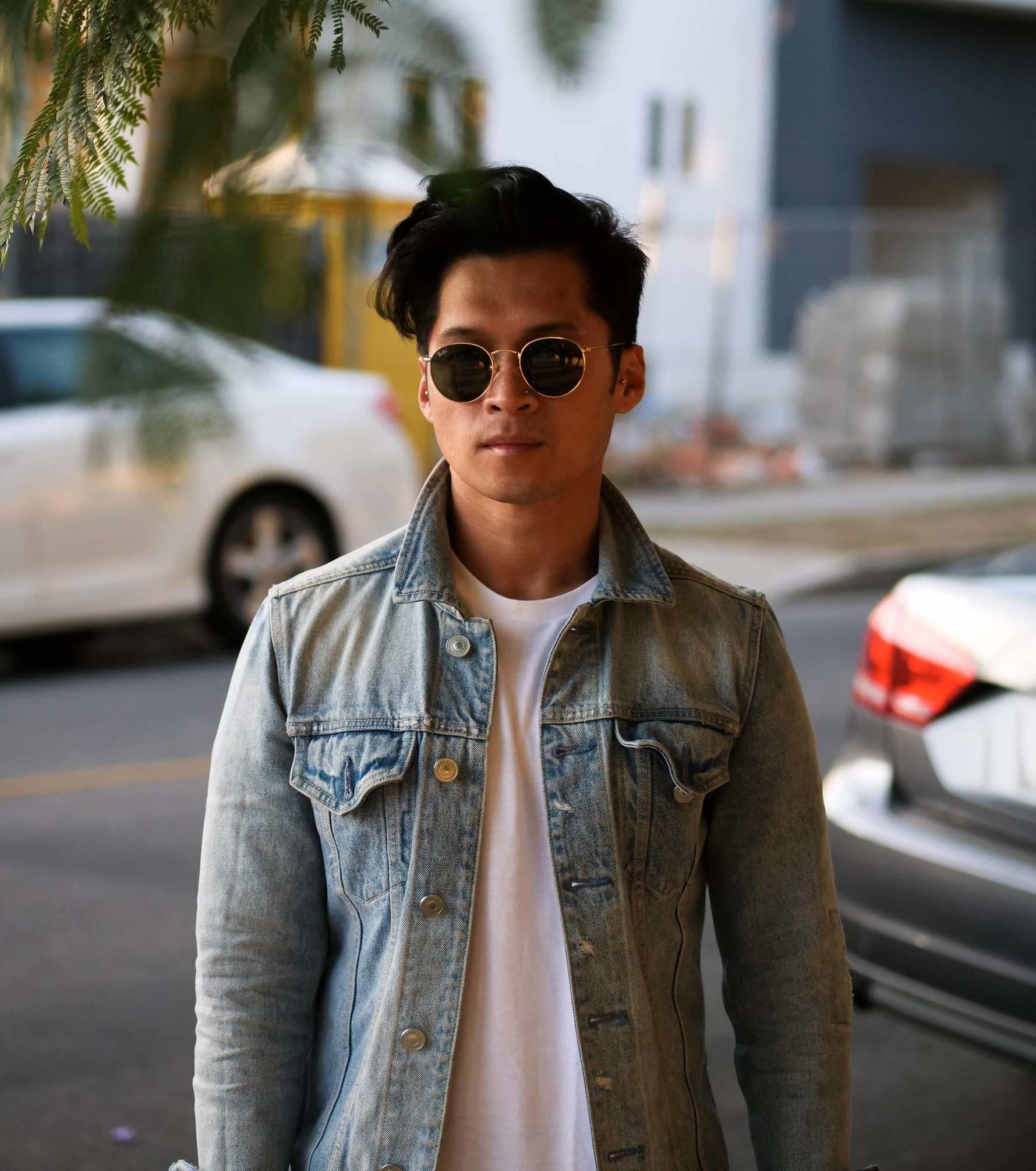 Myke wearing a denim jacket, white shirt and sunglasses