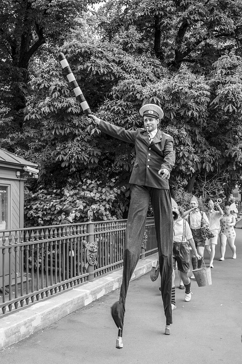 man on stilts leads march